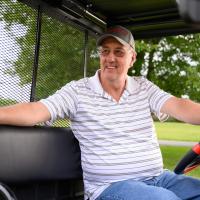 Danny smiles while sitting in his golf cart.