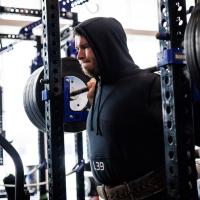 An action shot of Eli doing a deadlift with a considerable amount of weights on it.