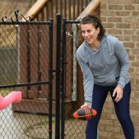 Geri stands in her driveway, getting ready to toss a football to her daughter.