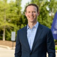 Dr. Stone stands smiling outside UK HealthCare Orthopaedic Surgery & Sports Medicine.