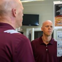 A.W. stares at a list of personal goals that he has taped to his mirror.