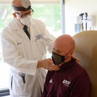 Dr. Valentino examines A.W.’s ear in his office.