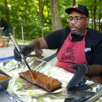 A candid photo of Joshua using a brush to marinate a rack of ribs.