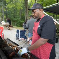 A candid photo of Joshua checking the meat on his smoker.