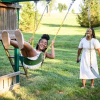 Kristen smiles as she catches some air on the swingset after being pushed by her mother.