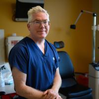 A photo of Dr. Peter Timoney smiling for the camera while sitting in his office.