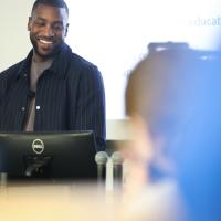 A candid photo of Michael smiling mid-presentation.
