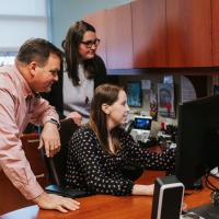 Dr. D’Orazio, Dr. Harrington, and Terra all look at the same computer screen in Dr. Harrington’s office.