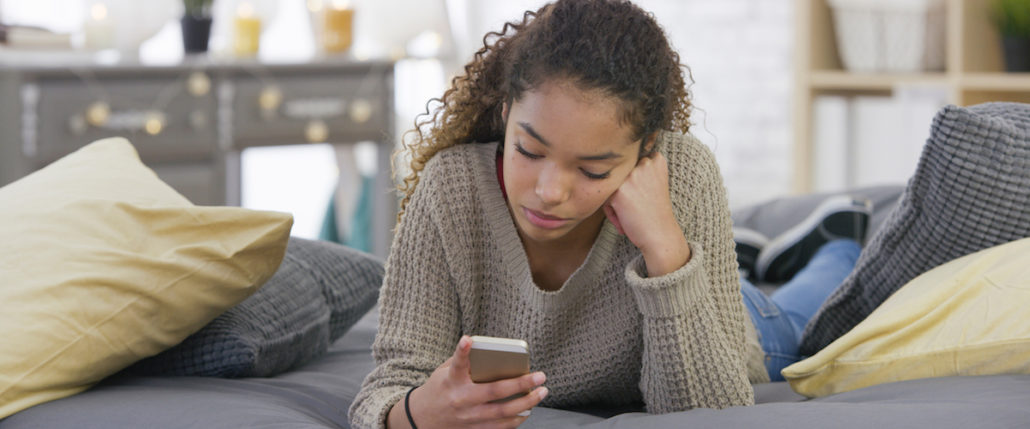 A teen talks on her phone.