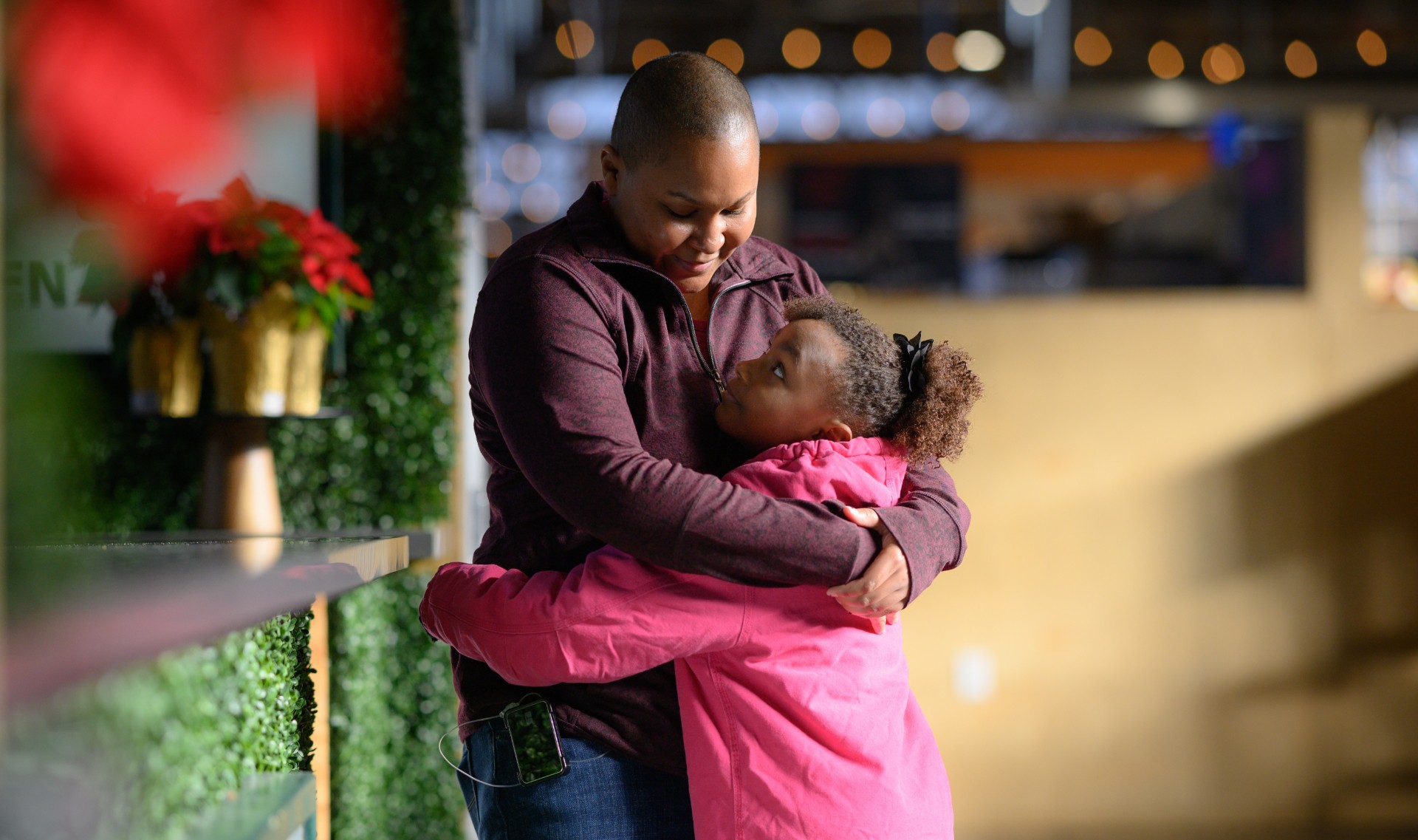 A photo of Essence looking up at Whitley as they hug.