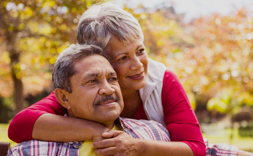 A woman hugs her husband.