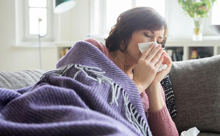 Sick woman blowing her nose.