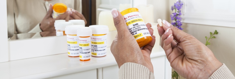 A woman holds a bottle of medicine.