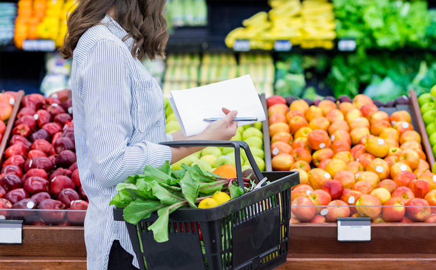 A woman shops in the produce section of the grocery.