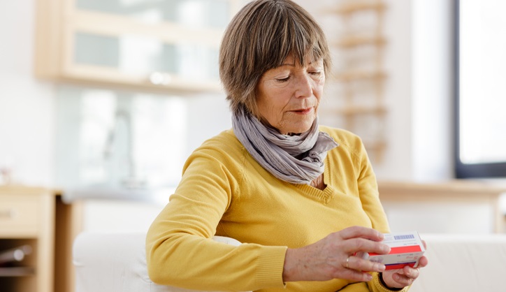 Woman looks at package of medicine