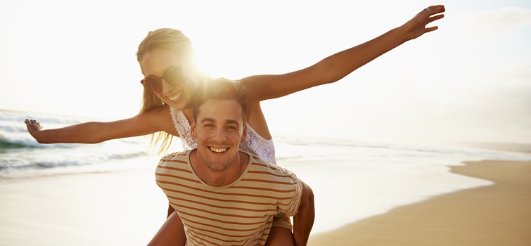 A young couple plays on the beach.