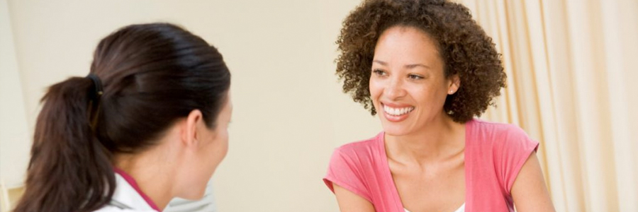 A young woman talks with her doctor.